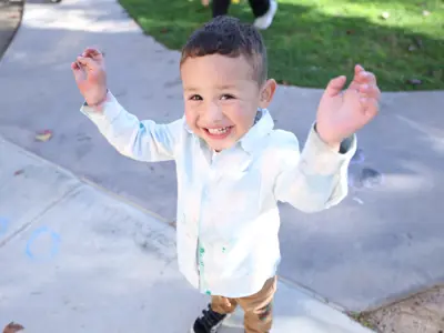 Young boy with arms outstretched smiling